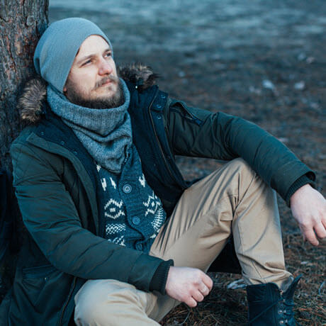 guy leaning against tree