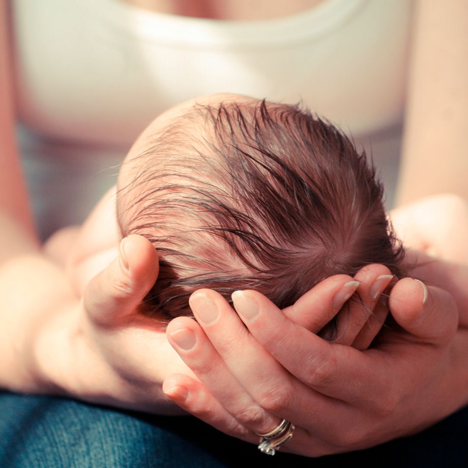 Newborn baby cradled in mothers arms