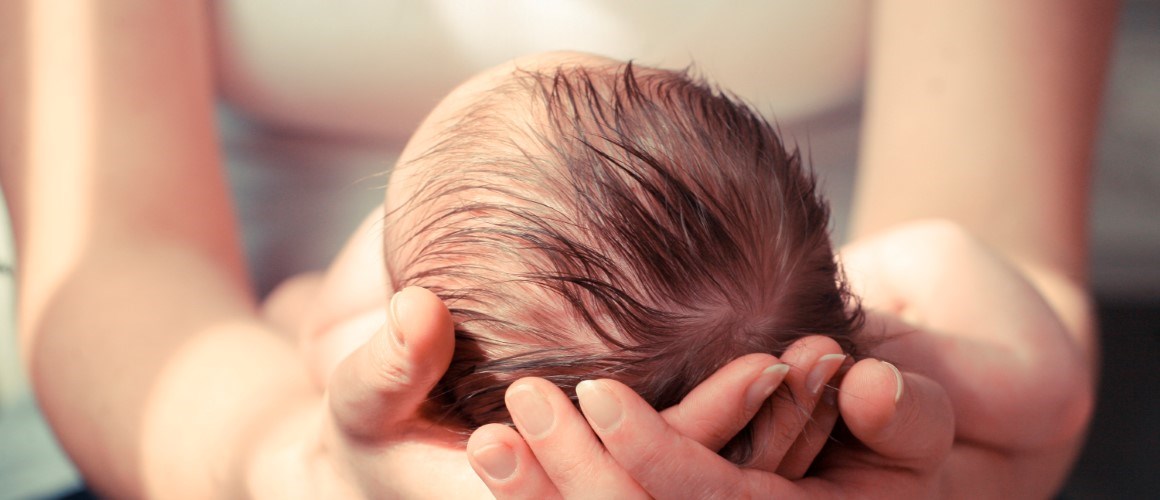 Woman holding newborn infant in her arms. 