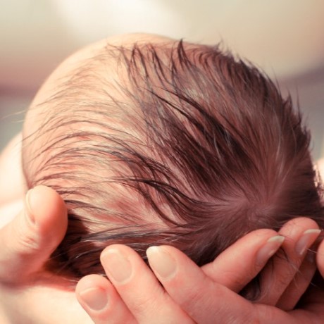 Woman holding newborn infant in her arms. 