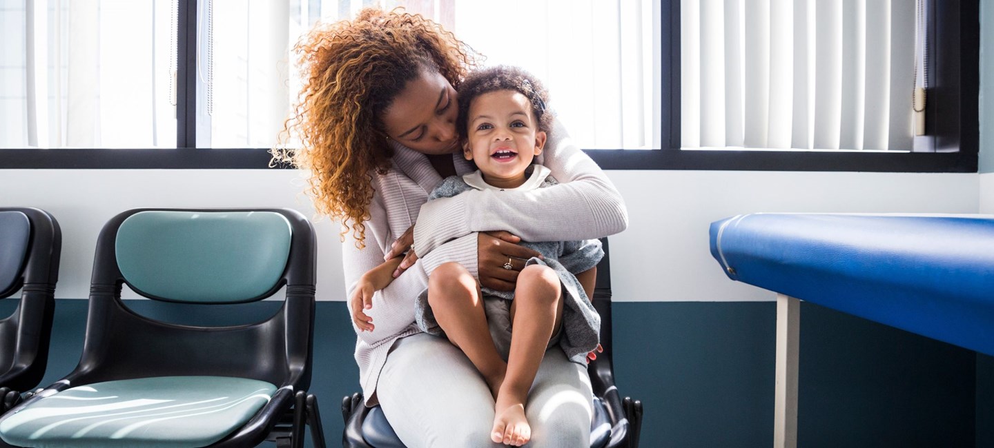 Parent holding a toddler on her lap